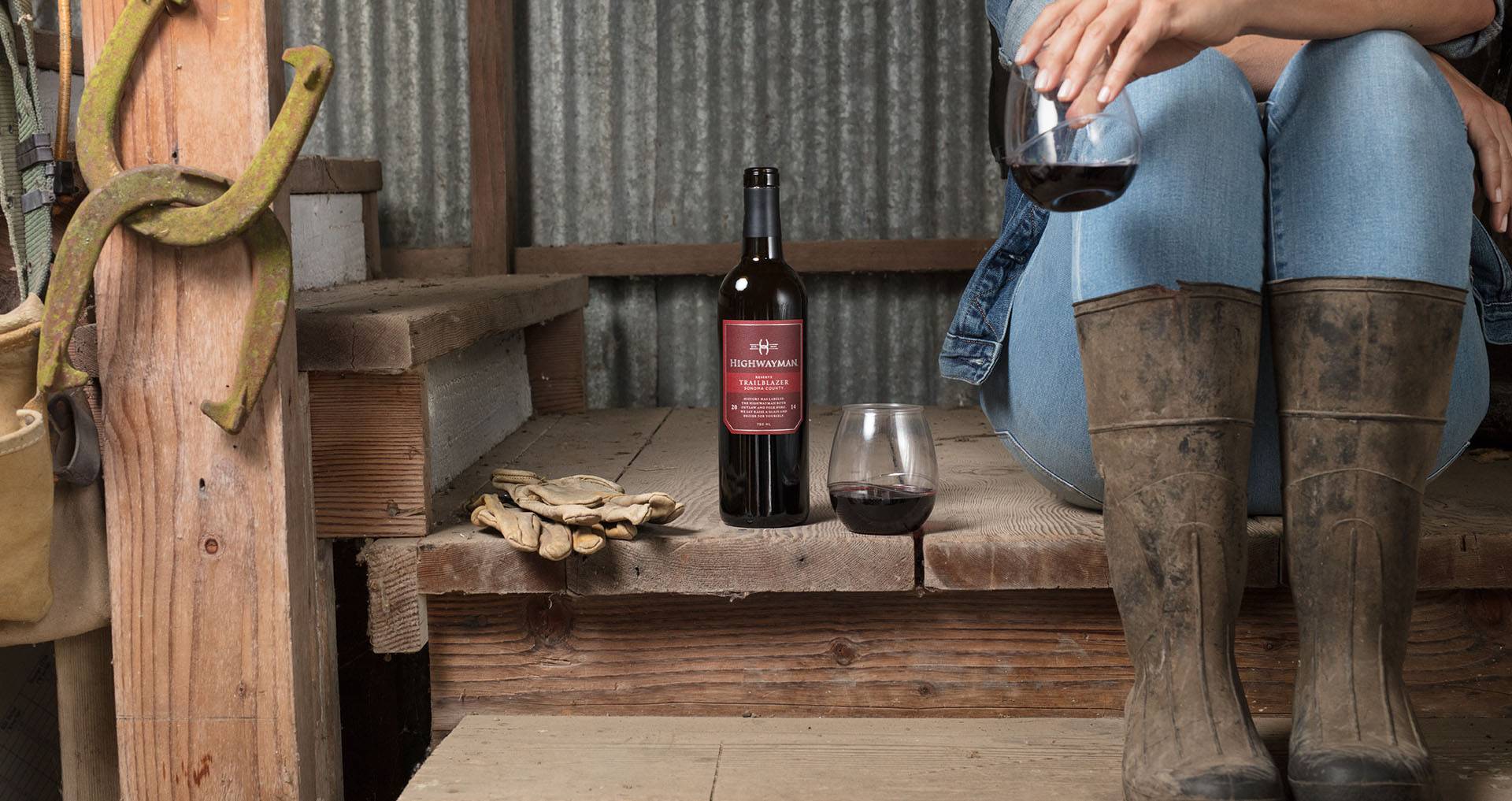 Highwayman Trailblazer photo with woman drinking a glass in a horse barn